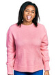 © Krakenimages.com - Beautiful hispanic woman wearing casual winter sweater sticking tongue out happy with funny expression. emotion concept.