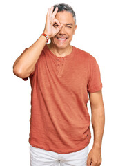 Poster - Handsome middle age man wearing casual clothes doing ok gesture with hand smiling, eye looking through fingers with happy face.