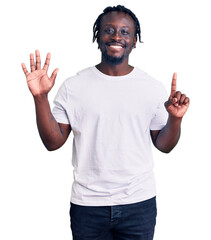 Canvas Print - Young african american man with braids wearing casual white tshirt showing and pointing up with fingers number six while smiling confident and happy.