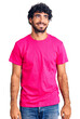 © Krakenimages.com - Handsome young man with curly hair and bear wearing casual pink tshirt looking away to side with smile on face, natural expression. laughing confident.