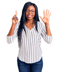 Sticker - Young african american woman wearing casual clothes and glasses showing and pointing up with fingers number six while smiling confident and happy.