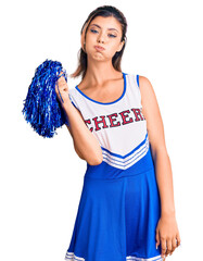 Canvas Print - Young beautiful woman wearing cheerleader uniform puffing cheeks with funny face. mouth inflated with air, crazy expression.