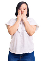 Sticker - Brunette woman with down syndrome wearing casual white tshirt afraid and shocked, surprise and amazed expression with hands on face