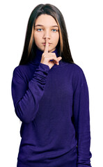 Sticker - Young brunette girl with long hair wearing turtleneck sweater asking to be quiet with finger on lips. silence and secret concept.