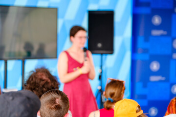 Poster - Anonymous woman speaking on stage during business meeting with colleagues