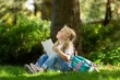 © BillionPhotos.com - School girl listening book in park. Concept of distance learning.