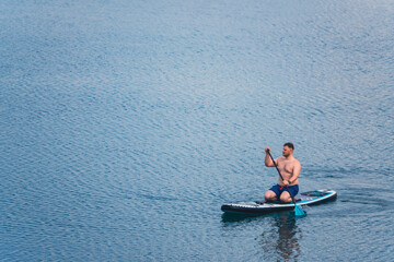 Wall Mural - man on paddleboard in the middle of the lake