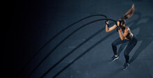 Effective Workout With A Rope. Sportswoman Trains In The Functional Training Gym, Performing Crossfit Exercises With A Battle Rope