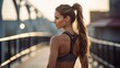 © Rithvik - Slim woman athlete adjusting her ponytail while standing in outdoors studio