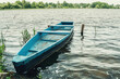 An old boat on the shore of a lake in the countryside. A boat for swimming on the lake. A fishing tool floating on water