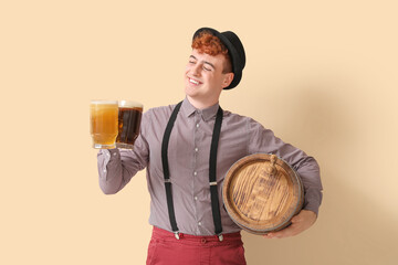 Young man in traditional German clothes with beer on beige background