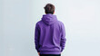 Young man from behind wearing a purple hooded sweatshirt. Purple hoodie mockup. Boy with modern short hair. Background with smooth and clean space with copy space. Generative ai.
