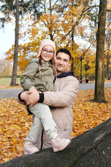 The father is holding his daughter in his arms. Family spending time together in the park