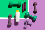 Fototapeta Sypialnia - Composition with bottle of sunscreen cream, dumbbells and skipping rope on color background