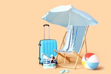 Poster - Deckchair with suitcase and beach accessories on beige background. Travel concept