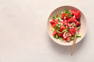 Wall Mural - Bowl of tasty watermelon salad on light background