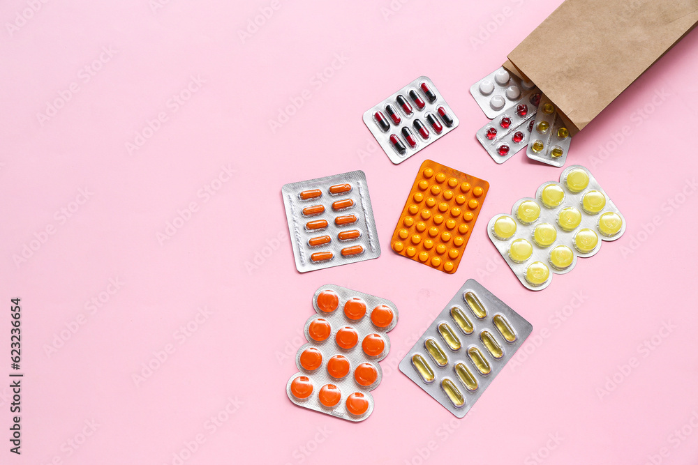 Shopping bag with different pills in blister packs on pink background