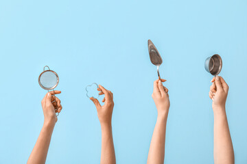 Wall Mural - Female hands with baking utensils on blue background