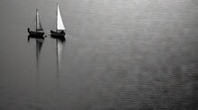  Two Sailboats Floating On A Lake With A Sky Background.  Generative Ai