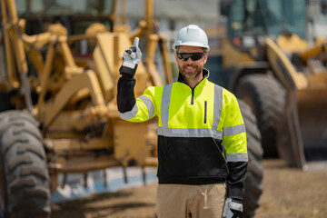 Builder in helmet with excavator for construction at the construction site. Machinery tractor with builder at buildings background. Excavator loader tractor and buider worker.