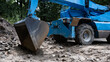 niebieskia koparka, ładowarka, ładuje kostke brukową, excavator, loader