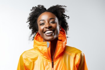 Wall Mural - Smiling african american woman in yellow raincoat on white background