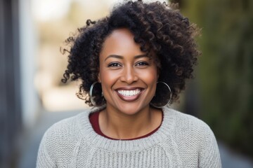 Wall Mural - Portrait of smiling african american woman with curly hair in city