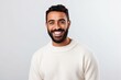 © Anne Schaum - Medium shot portrait photography of a happy Saudi Arabian man in his 30s wearing a cozy sweater against a white background