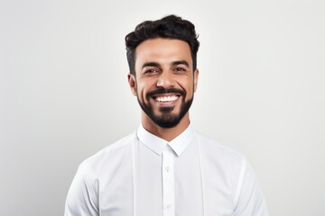 Medium shot portrait photography of a happy Saudi Arabian man in his 30s wearing a chic cardigan against a white background 