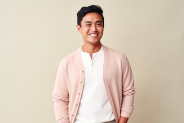 Portrait of a happy young asian man smiling against white background