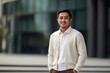 © Hanne Bauer - Portrait of a young asian businessman standing outside office building.