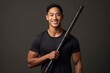 © Anne Schaum - Portrait of a young asian man holding baseball bat on grey background