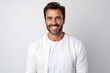 © Robert MEYNER - Portrait of happy mature man smiling at camera, looking at camera, standing against white background
