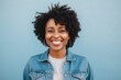 © Leon Waltz - Close-up portrait photography of a happy Nigerian woman in her 40s wearing a denim jacket against a pastel or soft colors background