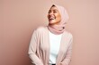 © Leon Waltz - Beautiful african american woman with hijab smiling on pink background