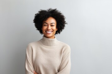 Wall Mural - Portrait of a smiling young african american woman standing against grey background