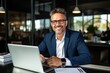 © Adriana - Smiling mature adult business man executive sitting at desk using laptop. Happy busy professional mid aged businessman ceo manager working on computer corporate technology in office