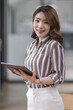 © David - Business, finance and employment, female successful entrepreneurs concept. Confident smiling asian businesswoman, office worker in office holding tablet, help clients