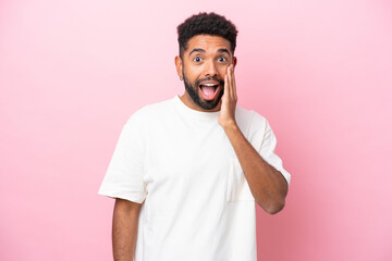 Wall Mural - Young Brazilian man isolated on pink background with surprise and shocked facial expression