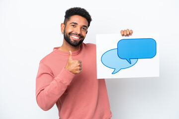 Wall Mural - Young Brazilian man isolated on white background holding a placard with speech bubble icon with thumb up