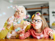 © Lumos sp - child grandparent granddaughter grandmother bubble soap blowing fun together girl grandchild family senior smiling woman female happy adult lifestyle generation childhood togetherness
