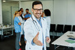 © Lumos sp - doctor portrait man hospital medical handshake hand agreement deal greeting partnership offer group team contract shake cooperation giving uniform health