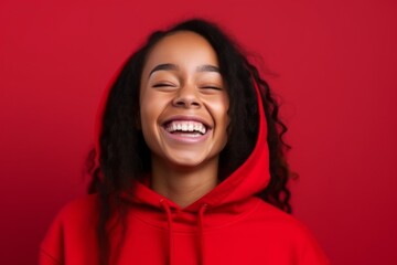 Wall Mural - Medium shot portrait photography of a happy girl in her 30s wearing a stylish hoodie against a red background. With generative AI technology