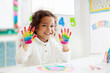 Leinwandbild Motiv Child drawing rainbow. Paint on hands.