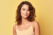 © Markus Schröder - Medium shot portrait photography of a beautiful girl in her 20s wearing a stylish tank top against a pastel yellow background. With generative AI technology