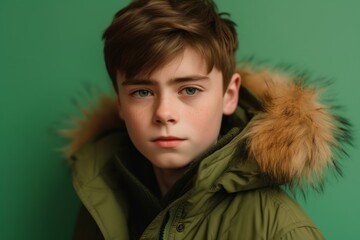 Wall Mural - Close-up portrait photography of a beautiful boy in his 30s wearing a warm parka against a pastel green background. With generative AI technology