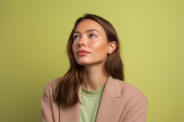 Wall Mural - Photography in the style of pensive portraiture of a glad girl in her 30s wearing a chic cardigan against a pastel green background. With generative AI technology