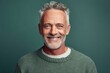 © Markus Schröder - Close-up portrait photography of a grinning mature man wearing a cozy sweater against a pastel green background. With generative AI technology