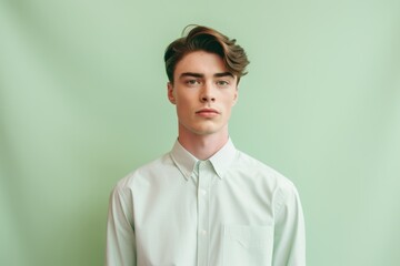 Wall Mural - Medium shot portrait photography of a beautiful boy in his 20s wearing an elegant long-sleeve shirt against a pastel green background. With generative AI technology