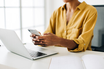 Canvas Print - Using a mobile phone in the office. Business woman sending a text message at work